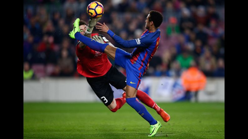 Leganes goalkeeper Iago Herrein swats at the ball near Barcelona forward Neymar during a Spanish league match in Barcelona on Sunday, February 19.