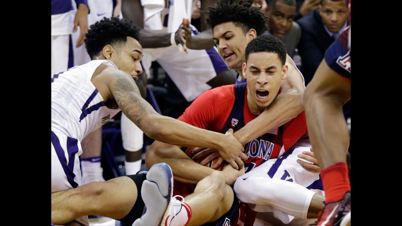 Arizona's Chance Comanche is swarmed by Washington players as they compete for a loose ball in Seattle on Saturday, February 18.