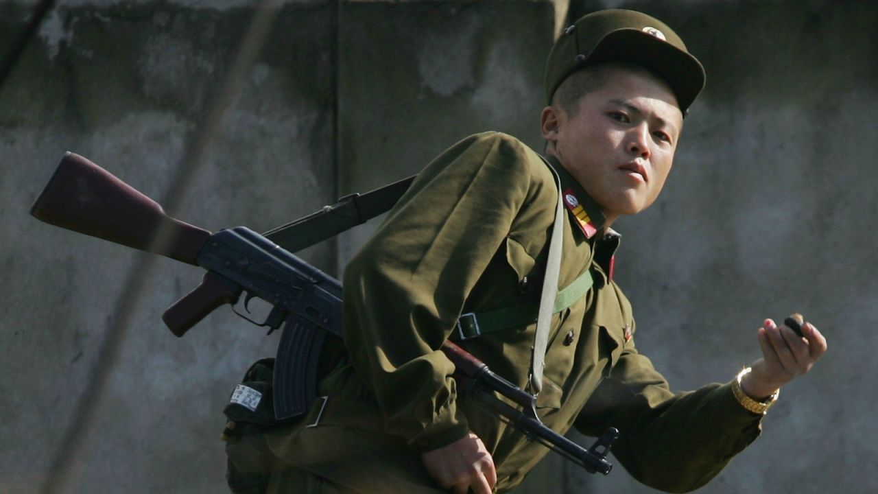 A North Korean border guard reacts to being photographed along the Yalu River.