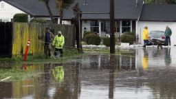 Residents walk down a flooded road on Monday, Feb. 20, 2017, in Salinas, Calif. Forecasters issued flash flood warnings Monday throughout the San Francisco Bay Area and elsewhere in Northern California as downpours swelled creeks and rivers in the already soggy region. (Nic Coury/Monterey County Weekly via AP)