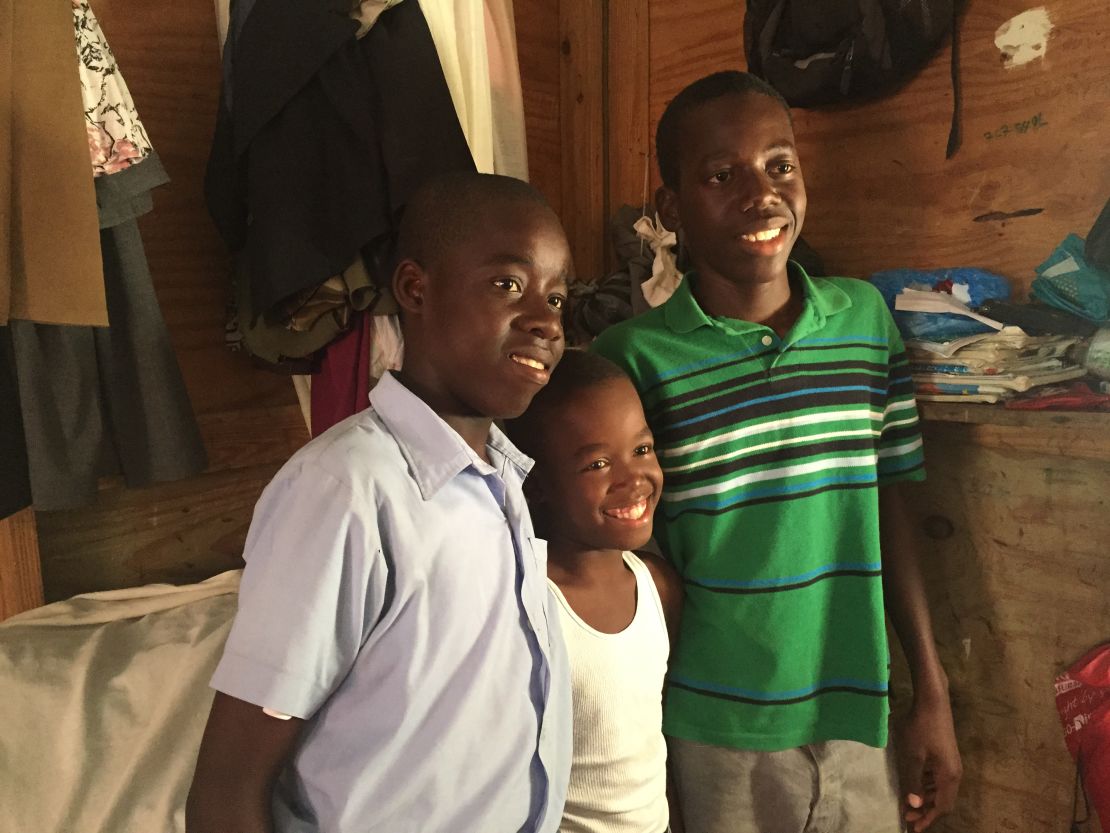 Monley (center) with his brothers Christoper (left) and Moise (right).