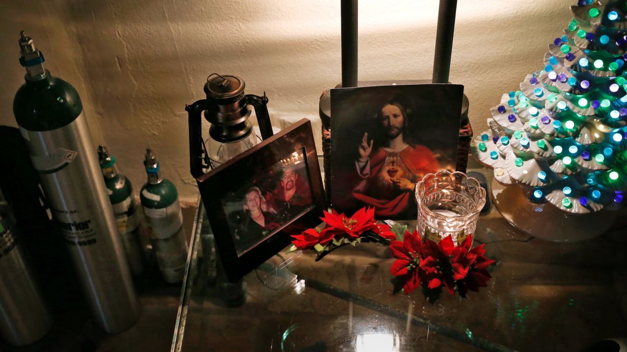 Medical equipment, photos of happier times and leftover Christmas decorations fill Marilyn Young's bedroom.