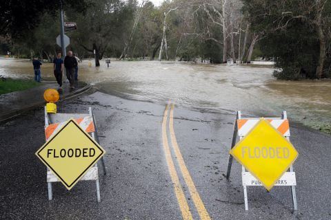 Signs block a road in Morgan Hill, which runs into the overflowing Coyote Creek, on February 21. 