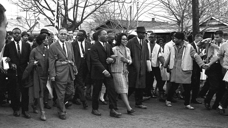 King, center, walks with his wife, Coretta, during the third march on March 21. About 3,200 people marched out of Selma under the protection of federal troops.
