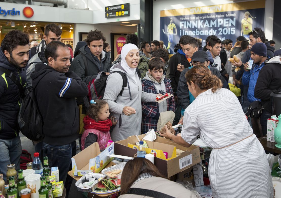 Volunteers hand food and drink to refugees arriving at Malmo station in Sweden in September 2015.