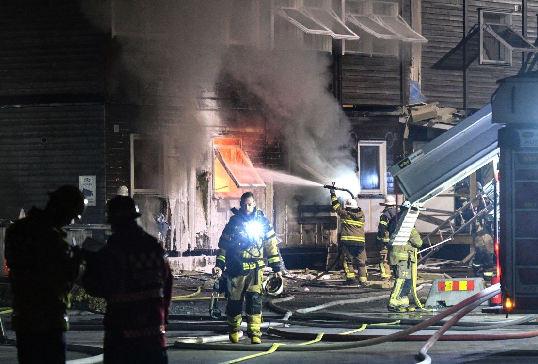 Firefighters tackle a suspected arson attack at a refugee accommodation block in Fagersjo, south of Stockholm, in October 2016.
