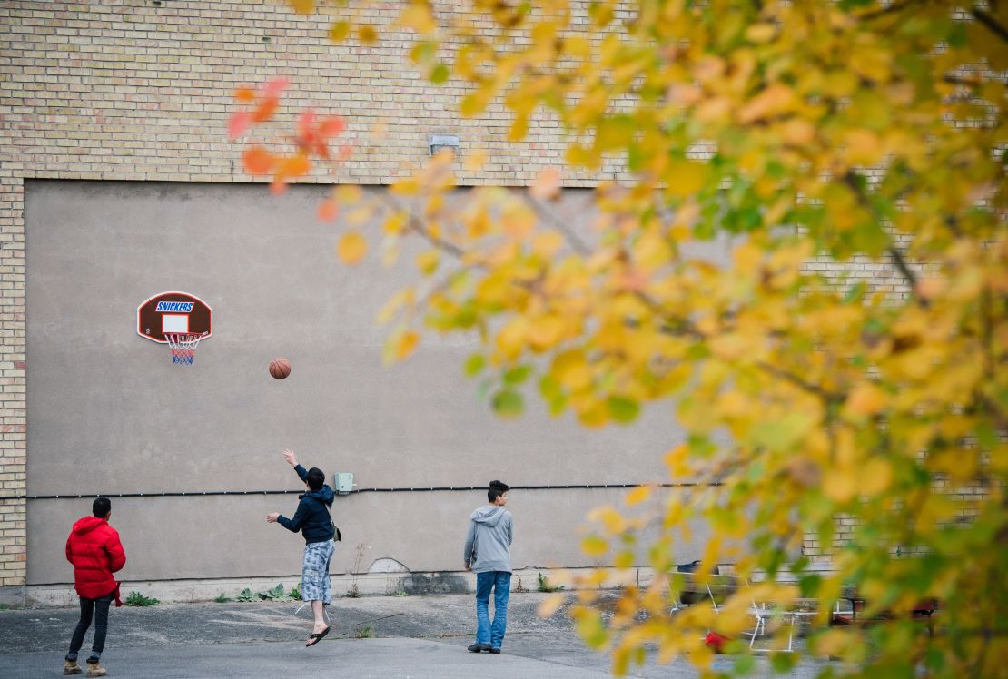 Refugees play basketball outside a shelter while waiting to find out if they will be granted asylum.