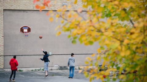 Refugees play basketball outside a shelter while waiting to find out if they will be granted asylum.