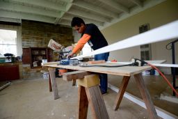 Workers rush to finish flooring for homes meant to hide immigrants.