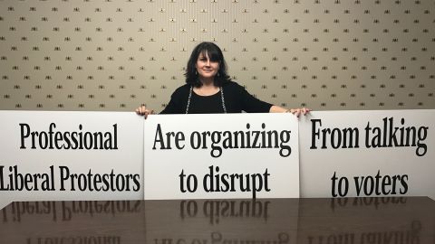 Candace Preston, a staffer for Rep. Gaetz, holds up signs that are his backup plan if protestors disrupt his Thursday night town hall - his speech printed entirely on posters.