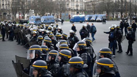 Riot police forces stand guard.