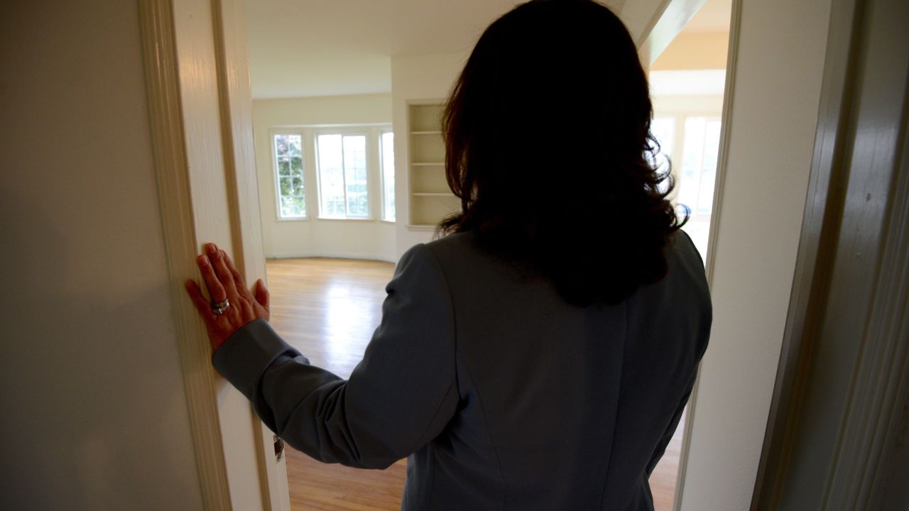 Pastor Ada Valiente stands in the doorway of a room being readied for immigrants.