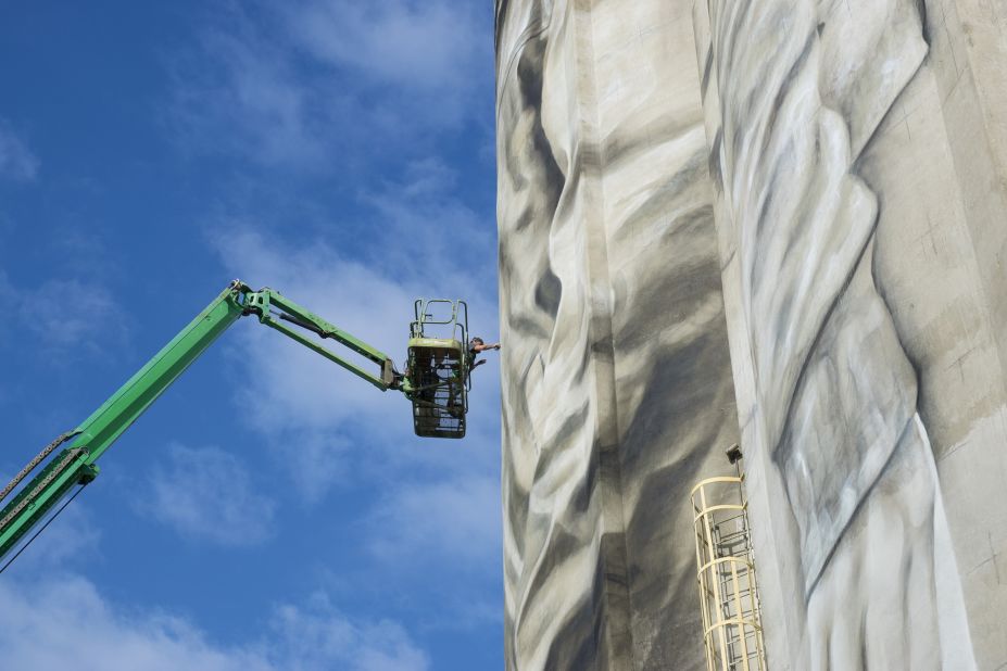 Van Helten uses a cherry picker to paint his silo mural entitled "Unity" in Jacksonville, Florida, US.