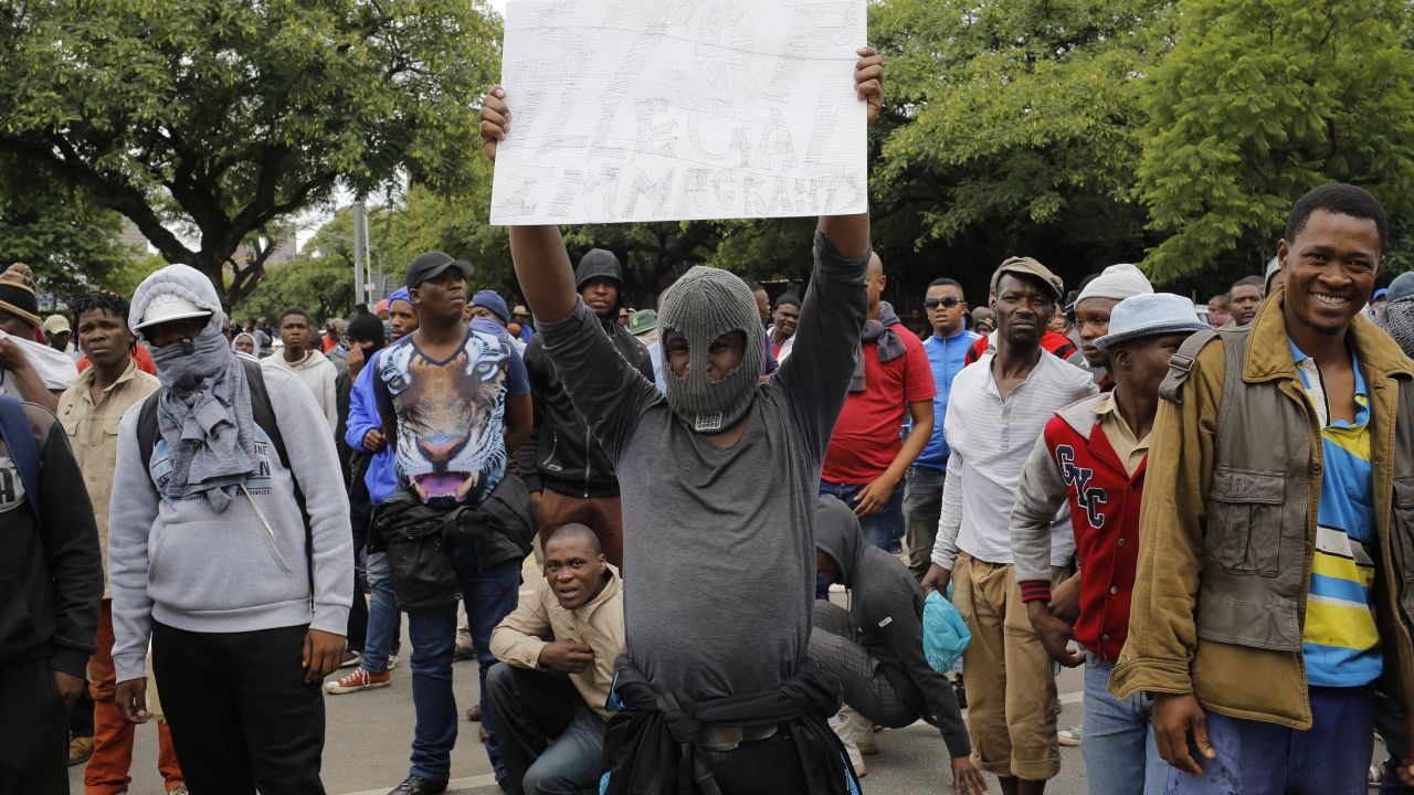 A South African holds a sign calling for foreign residents to leave the city during a march in Pretoria.