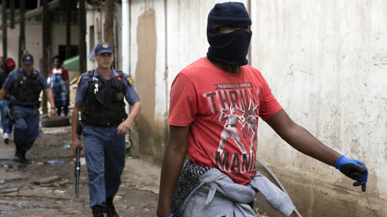 Police follow a South African protester in the latest wave of anti-immigrant protests to break out in the capital.