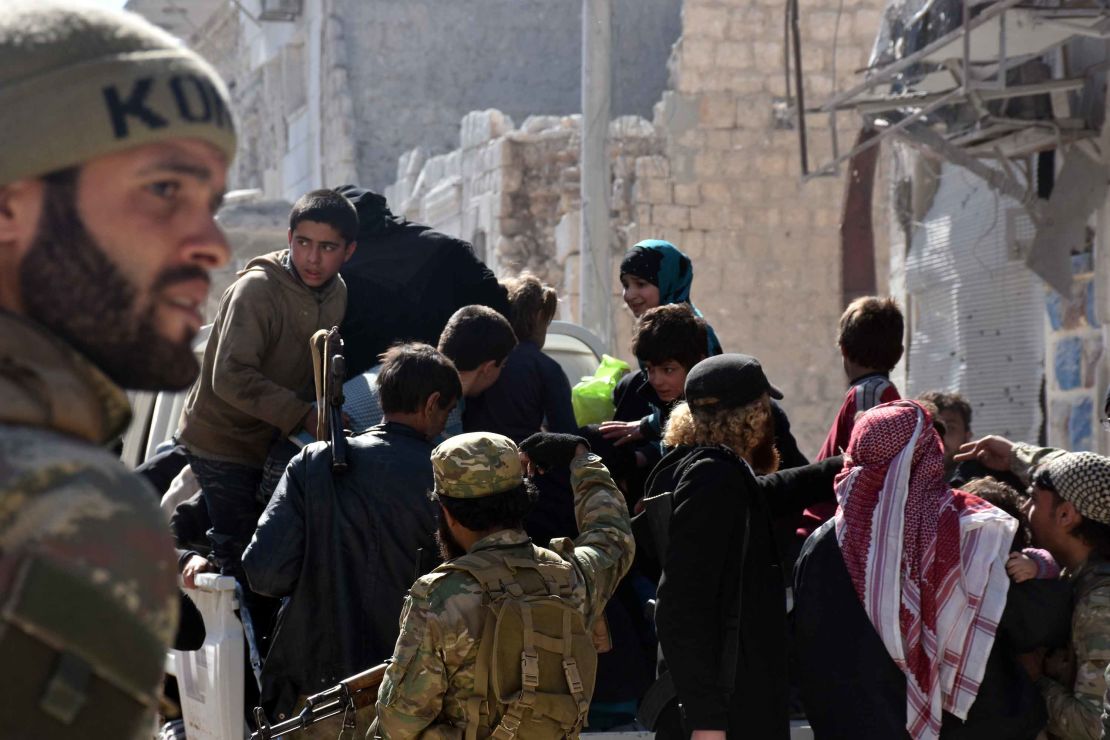 Members of the Free Syrian Army escort civilians Thursday after taking the center of al-Bab from ISIS.