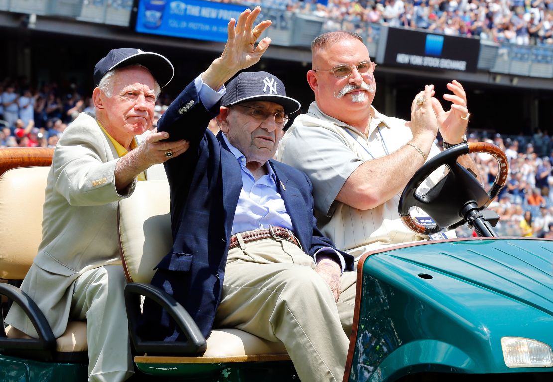 With help from former teammate New York Yankee Whitey Ford (left), former New York Yankee Yogi Berra (center) is introduced during the team's Old Timers Day in 2014.