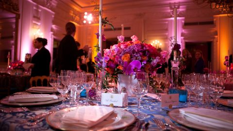 White House State Dining Room 2011. A vivid bouquet of orange and fuchsia flowers with accents of hot pink Phalaenopsis orchids makes a strong statement for the annual National Governors Association Dinner at the White House state dining room. The historic "Charleston" candlesticks are wrapped with blooming jasmine vine. The Lady Bird and President Johnson china service, featuring wildflowers from across America, reflects the gathering of Governors from all 50 states.