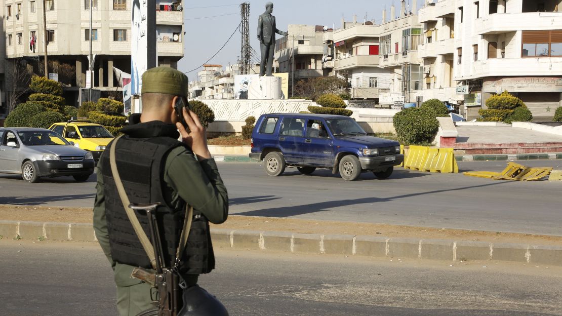 A Syrian government forces member mans a checkpoint at the President square in Homs.