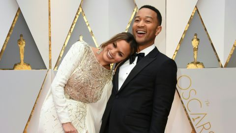 John Legend (R) and US model and wife of John Legend Chrissy Teigen arrive on the red carpet for the 89th Oscars on February 26, 2017 in Hollywood, California. / AFP / VALERIE MACON (Photo credit should read VALERIE MACON/AFP/Getty Images)
