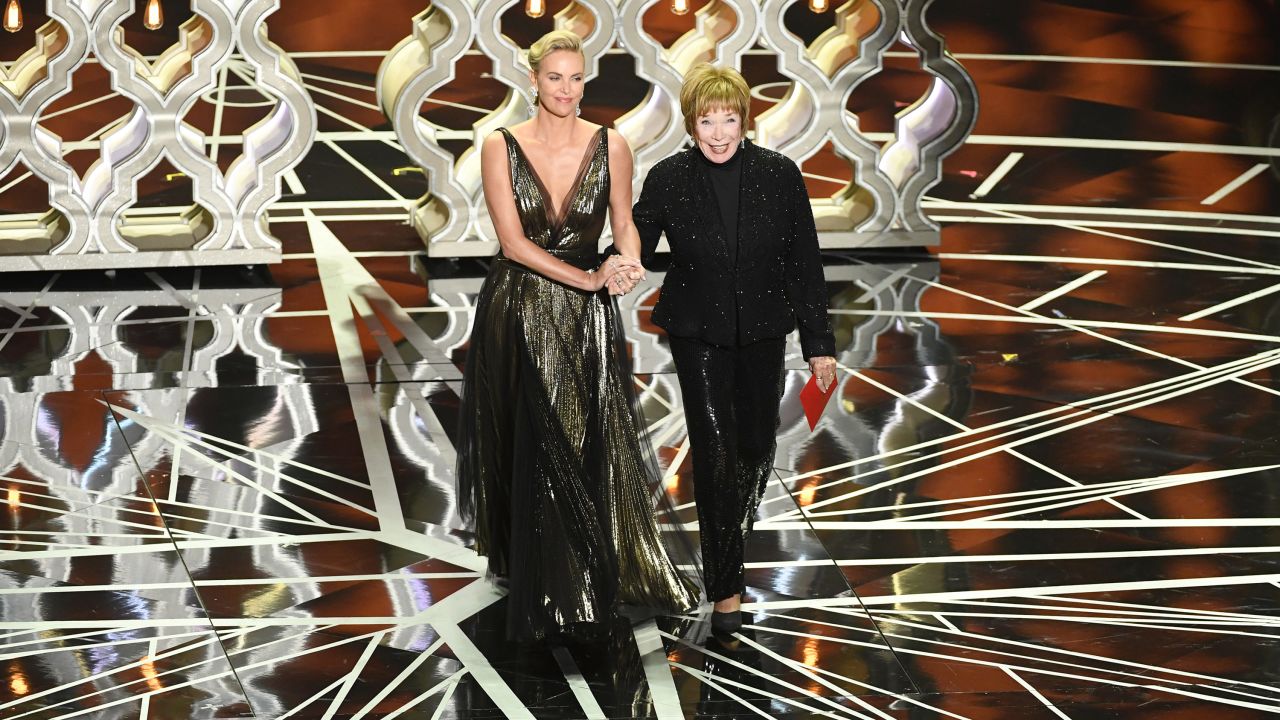 Charlize Theron, left, and Shirley MacLaine walk on stage to present an award. Theron said MacLaine inspired her to get into acting.