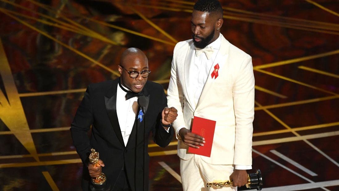 "Moonlight" director Barry Jenkins, left, and writer Tarell Alvin McCraney accept the Oscar for best adapted screenplay. The film was based on McCraney's play "In Moonlight Black Boys Look Blue."
