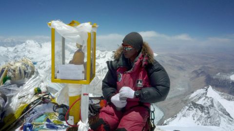 Sitting on top of the world. A sherpa at the summit of Mount Everest.