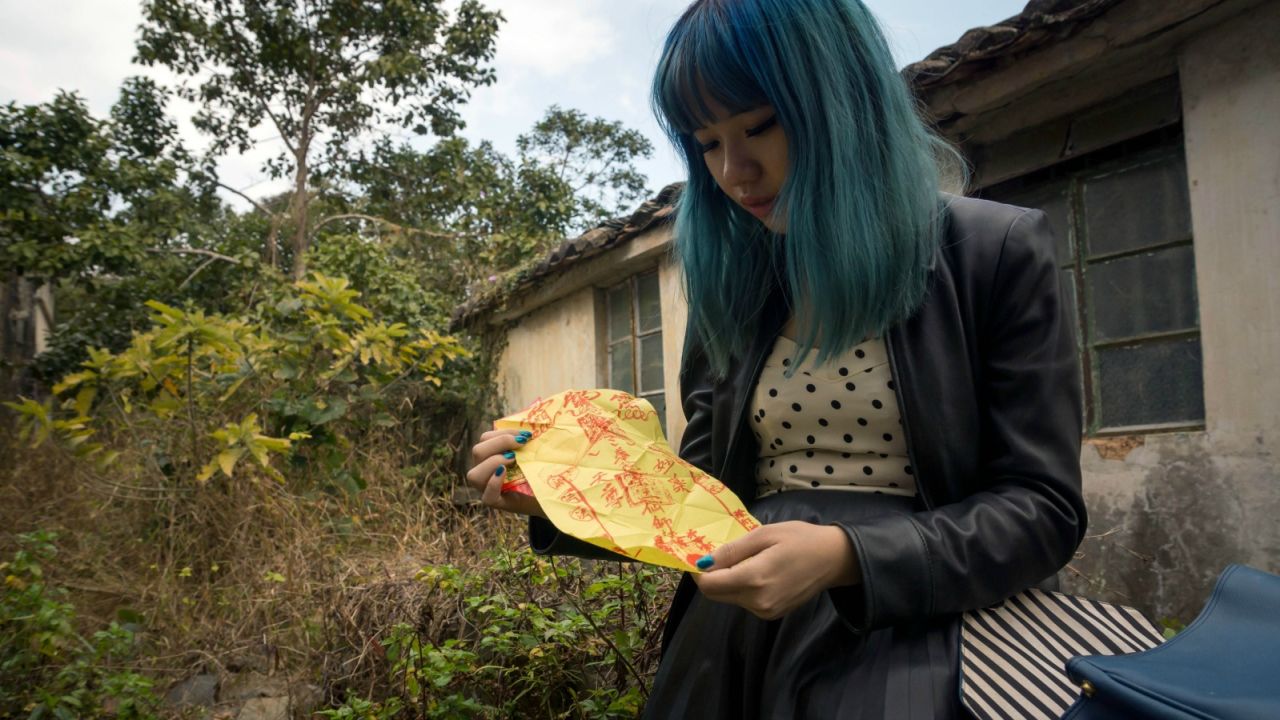 An urban explorer in Hong Kong shows a lucky charm she uses to protect her from ghosts. 