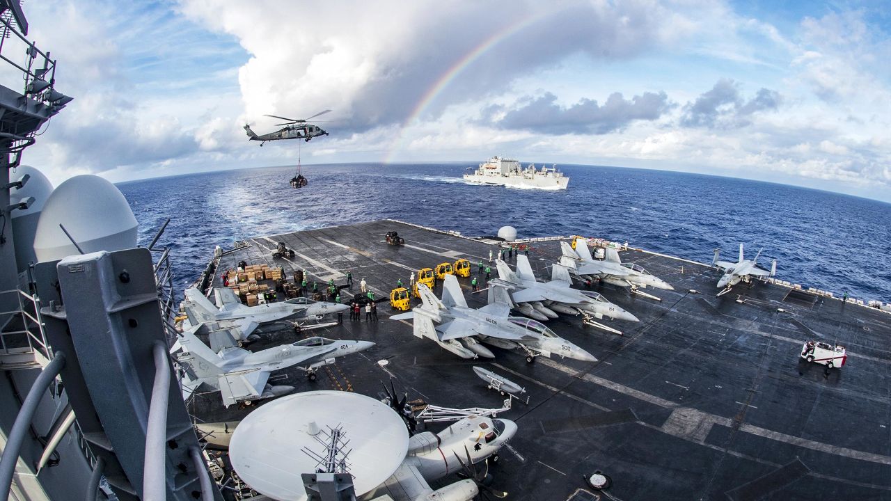 A rainbow is seen near the USS Carl Vinson, foreground, and the USNS Charles Drew during a replenishment operation in the Pacific Ocean on Friday, February 3.
