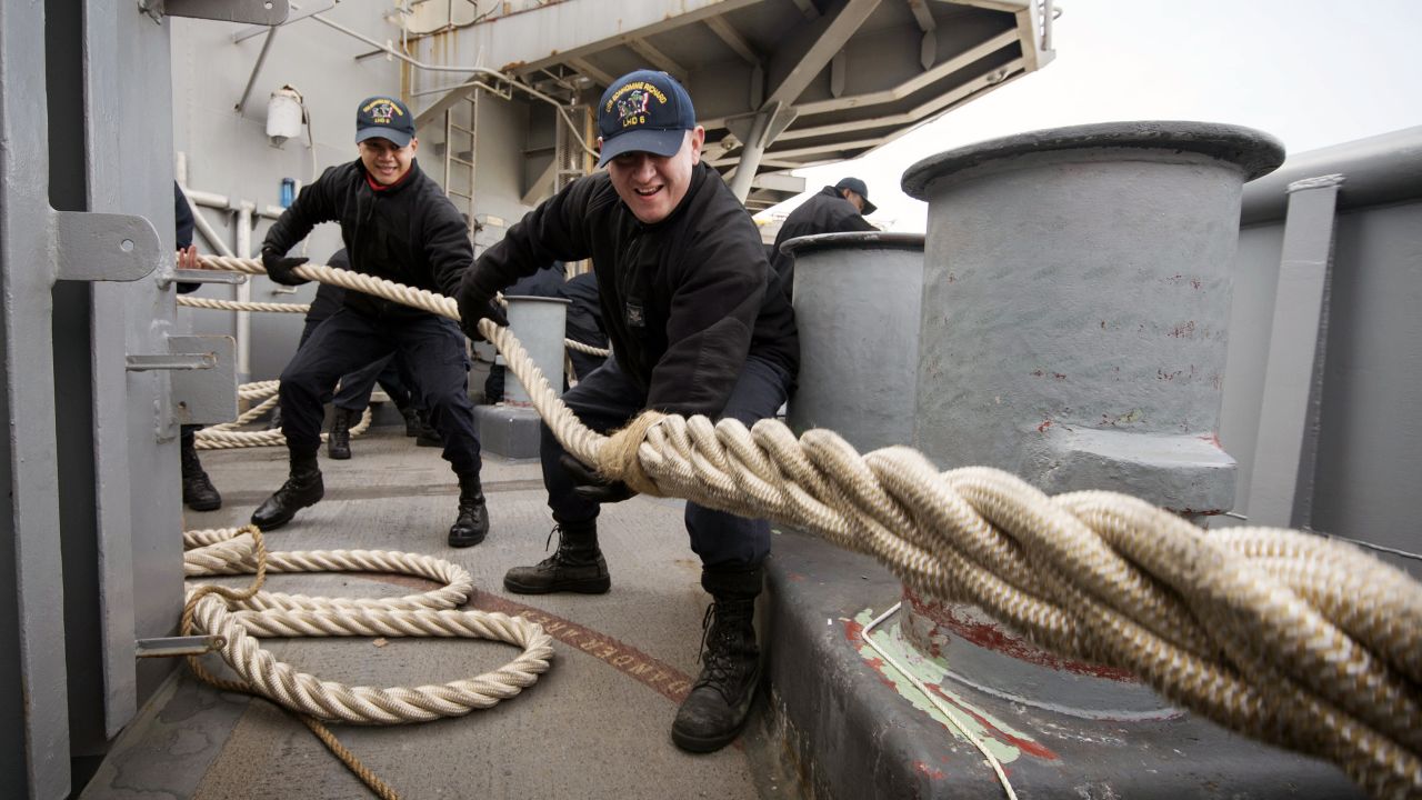 Two sailors heave a mooring line on the fantail of the USS Bonhomme Richard as the amphibious assault ship prepares to leave Sasebo, Japan, on Monday, February 27. The ship was on a routine patrol in the region.