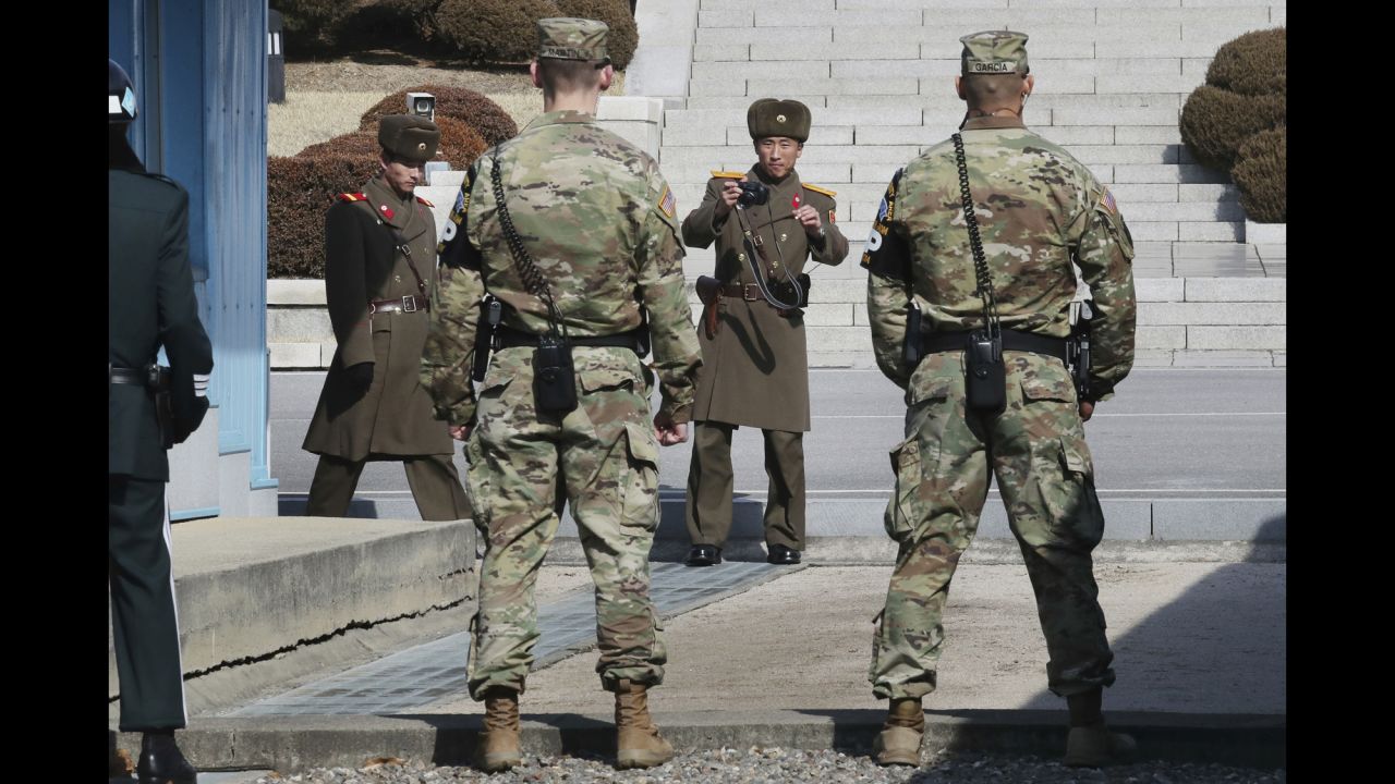 North Korean soldiers, background, look at US soldiers standing guard as Australia's foreign minister visits the border village of Panmunjom on Saturday, February 18.