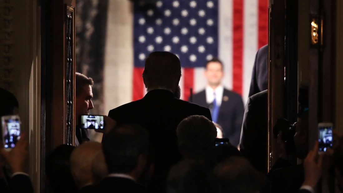 Trump stands in the doorway of the House chamber while being introduced.