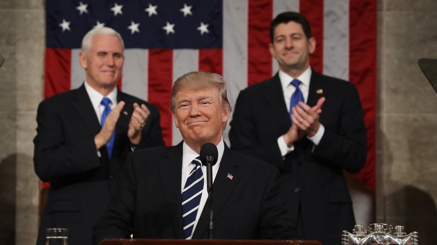 Vice President Mike Pence (L) and Speaker of the House Paul Ryan (R) applaud as President Donald J. Trump (C) arrives to deliver his first address to a joint session of the U.S. Congress on February 28, 2017.