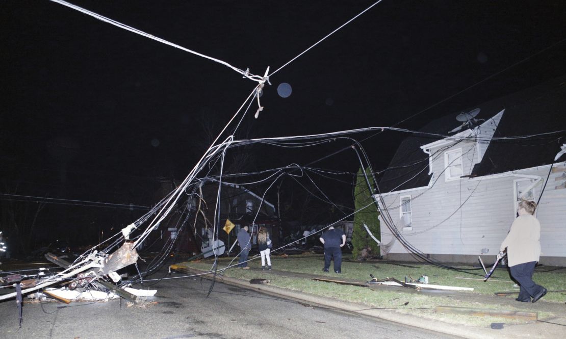 People walk past downed wires after a storm moved through Naplate, Illinois, on Tuesday.