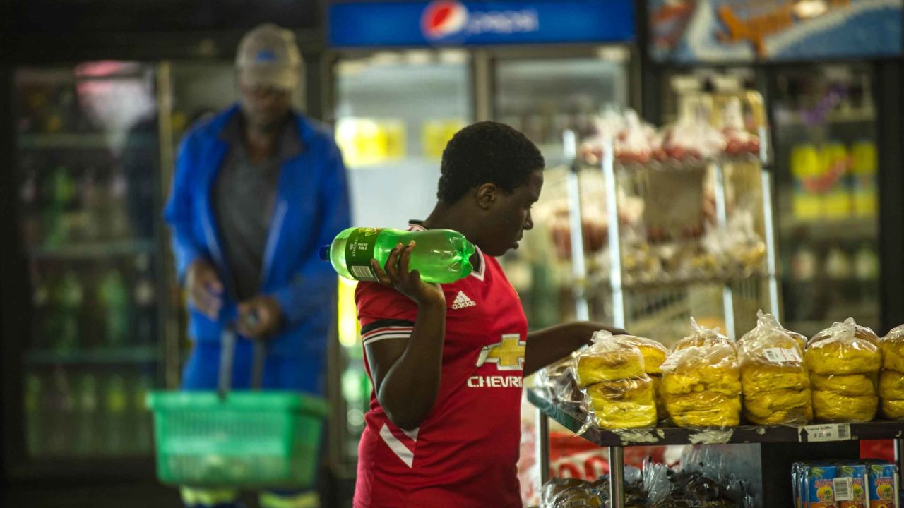 A woman holds a bottle of soft drink at a local supermarket in Greater Johannesburg. 