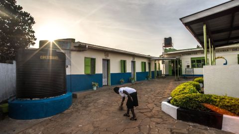 A RHU staff member sweeps the clinic's courtyard in the early morning before the first patients arrive.