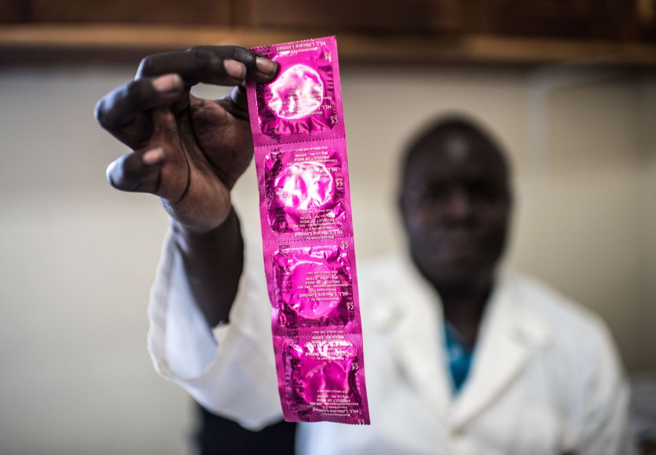Service provider, Cristopher Okuru, displays a string of condoms at a RHU clinic in Gulu. Currently, only 30% of sexually active Ugandan adolescents have access to contraceptives, according to RHU. 