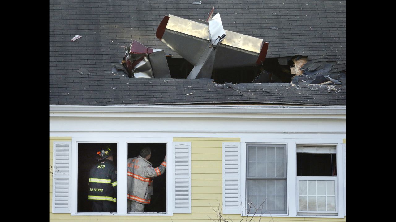 Firefighters investigate a condominium building where a single-engine aircraft crashed in Methuen, Massachusetts, on Tuesday, February 28. The pilot was killed. No one in the building was hurt.