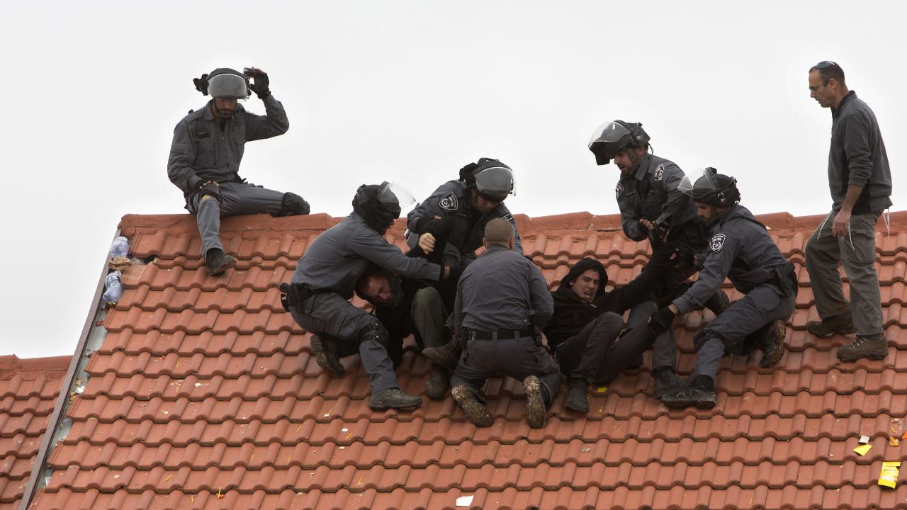 Israeli police officers remove settlers from a rooftop in the West Bank settlement of Ofra on Wednesday, March 1. Israeli forces were demolishing nine homes in Ofra after the Supreme Court ruled they were built on private Palestinian land without a permit. Hundreds of protesters <a href="http://www.cnn.com/2017/02/28/middleeast/ofra-protests/" target="_blank">tried to resist the evacuation,</a> standing in circles and singing religious songs inside the homes. 