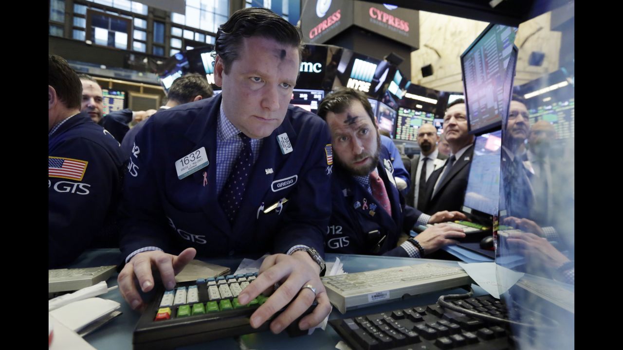 Gregg Maloney, left, and Michael Pistillo work at their post on the floor of the New York Stock Exchange on Wednesday, March 1. It was Ash Wednesday, the beginning of the holy season of Lent for many Christians in the Western church.