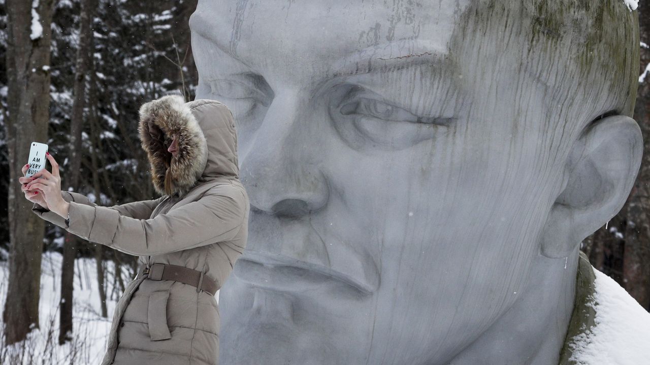 A woman takes a selfie with a statue of former Soviet leader Vladimir Lenin at a museum outside St. Petersburg, Russia, on Saturday, February 25.