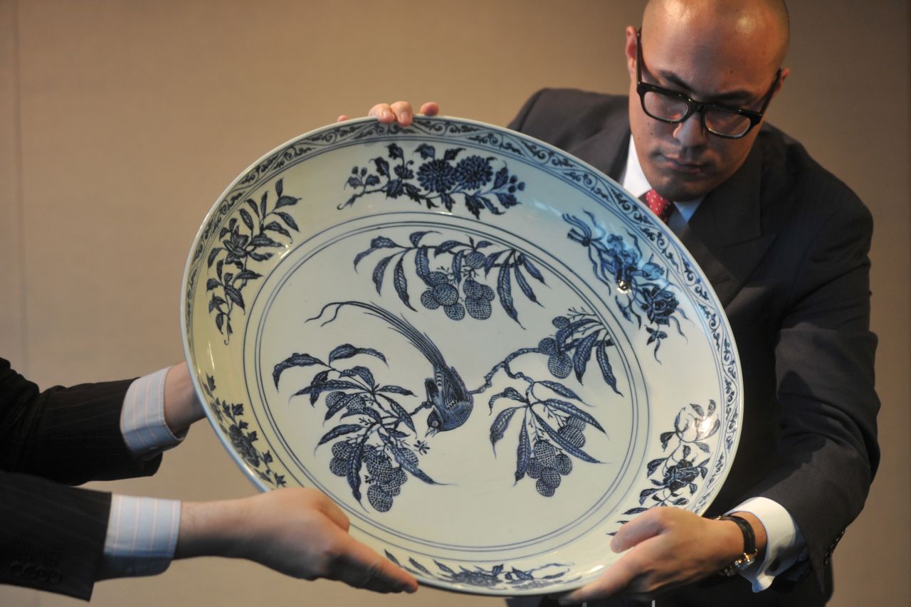 A blue and white 'Bird On A Lychee Branch Charger,' held by the deputy chairman for Sotheby's Asia, Nicolas Chow prior to auction