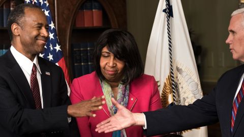US Secretary of Housing and Urban Development Ben Carson (L) is congratulated by US Vice President Mike Pence (R) as his wife Candy Carson (2L) and granddaughter Tesora Carson watch during his swearing in ceremony in the Eisenhower Executive Office Building on March 2, 2017 in Washington, DC. / AFP PHOTO / Brendan Smialowski (Photo credit should read BRENDAN SMIALOWSKI/AFP/Getty Images)