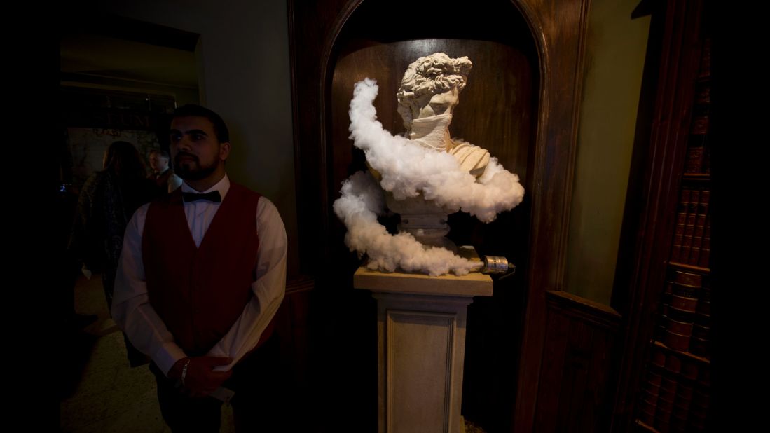 An employee stands next to another piece of art in the restaurant area of the hotel. 