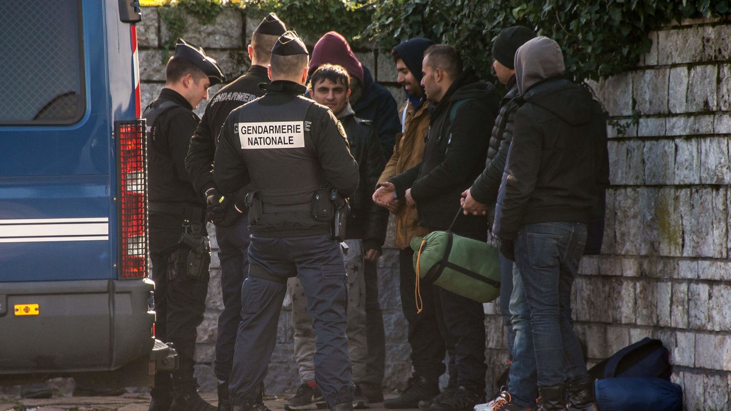 French police examine the identity documents of migrants in Calais.