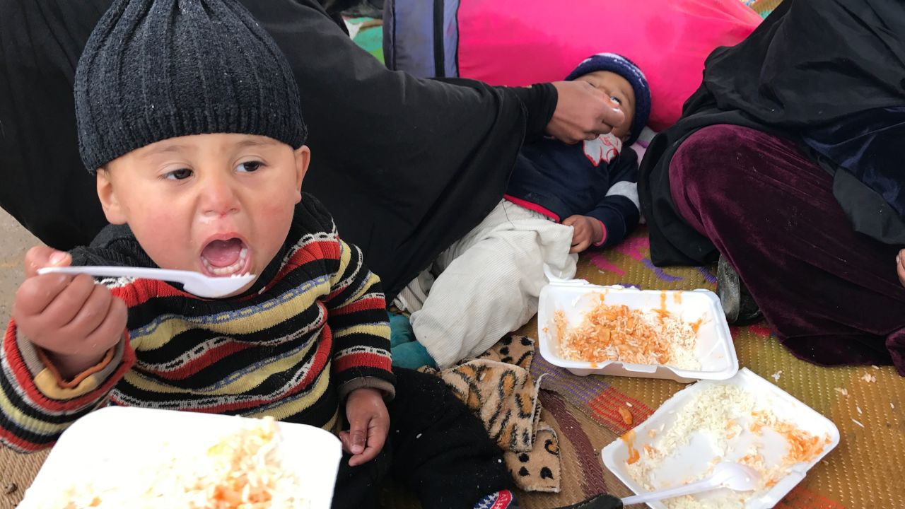 An Iraqi child eats his first hot meal in 10 days at an Iraqi military reception point for internally displaced people south of Mosul.