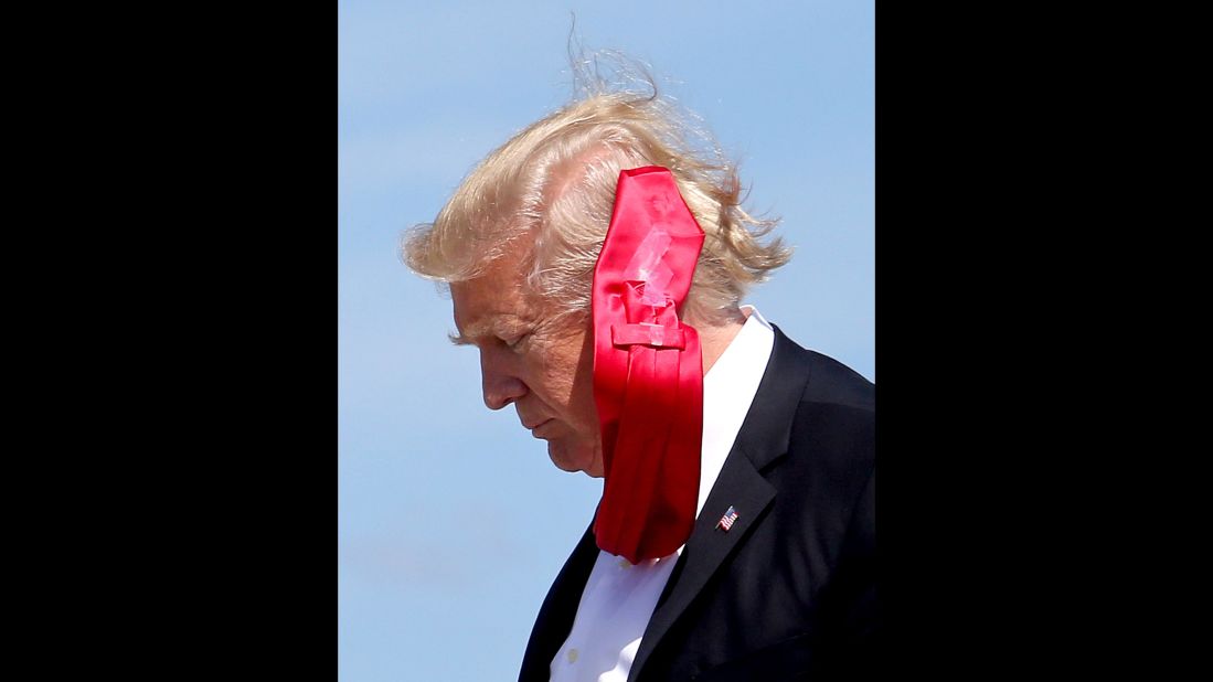 A strong wind blows President Trump's tie as he arrives at Orlando International Airport on Friday, March 3.