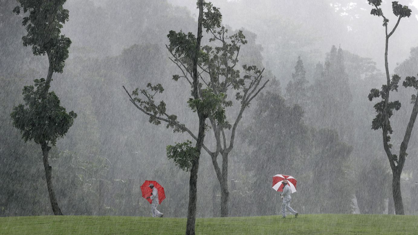 Course marshals carry umbrellas at an LPGA event in Singapore on Friday, March 3.