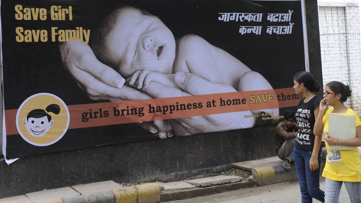 Women walk past a billboard in New Delhi in 2010. India has long struggled with sex-selective abortions, leading to a growing gender gap.
