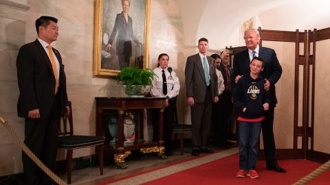 President Donald Trump stands with 10-year-old Jack Cornish of Birmingham, Alabama, as he surprises visitors during the official reopening of public tours at the White House on March 7, 2017.